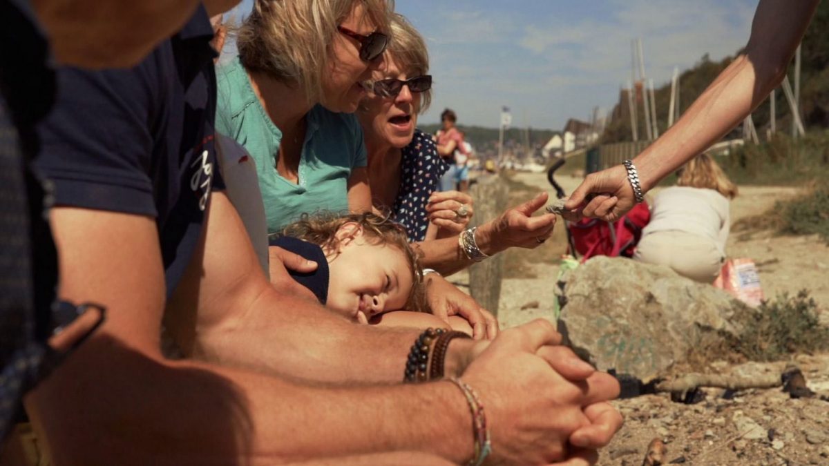 Frau inspiziert Fossil in Villers-sur-Mer